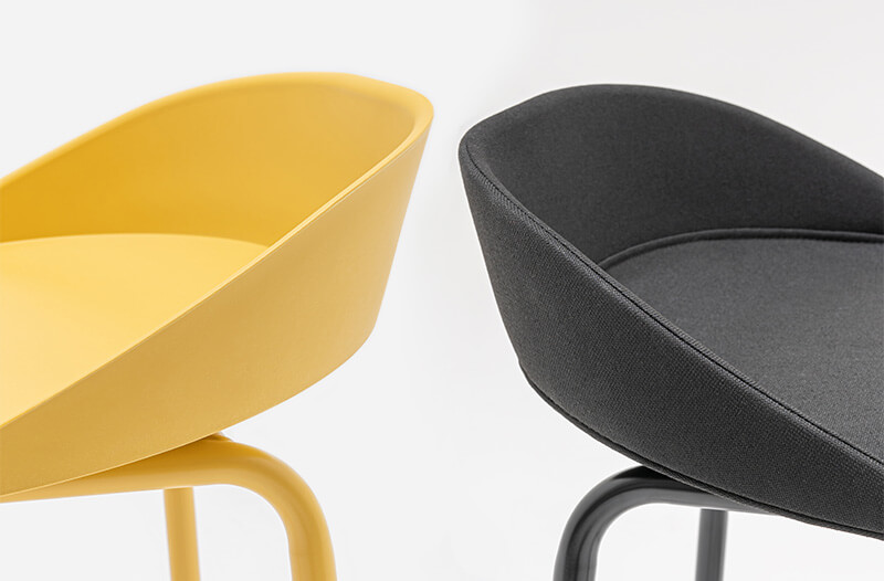 Schwarze hohe Hocker ohne Rückenlehne, die um einen hohen Tisch in einem modernen Büro mit großem Fenster herum angeordnet sind